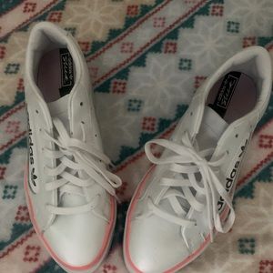 white ADIDAS sneakers with neon orange stripe